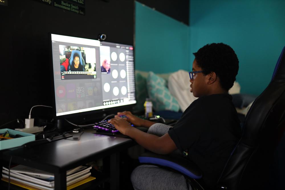 Child using computer for school in a darkened room